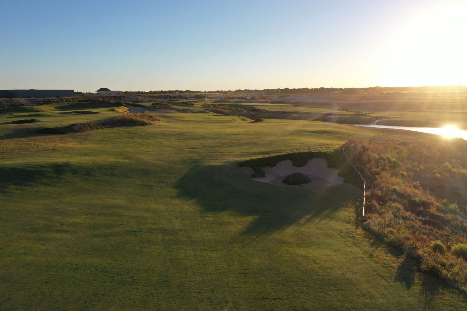 The Red Feather golf course at golden hour — links-style fairways and native grasses.